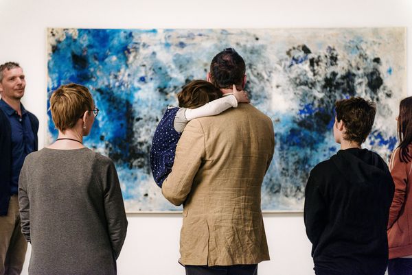 Berlinische-Galerie-Ausstellungen-Berlin-Besuch Foto: Erwachsene und ein Kind während einer Führung stehen vor einem Gemälde.